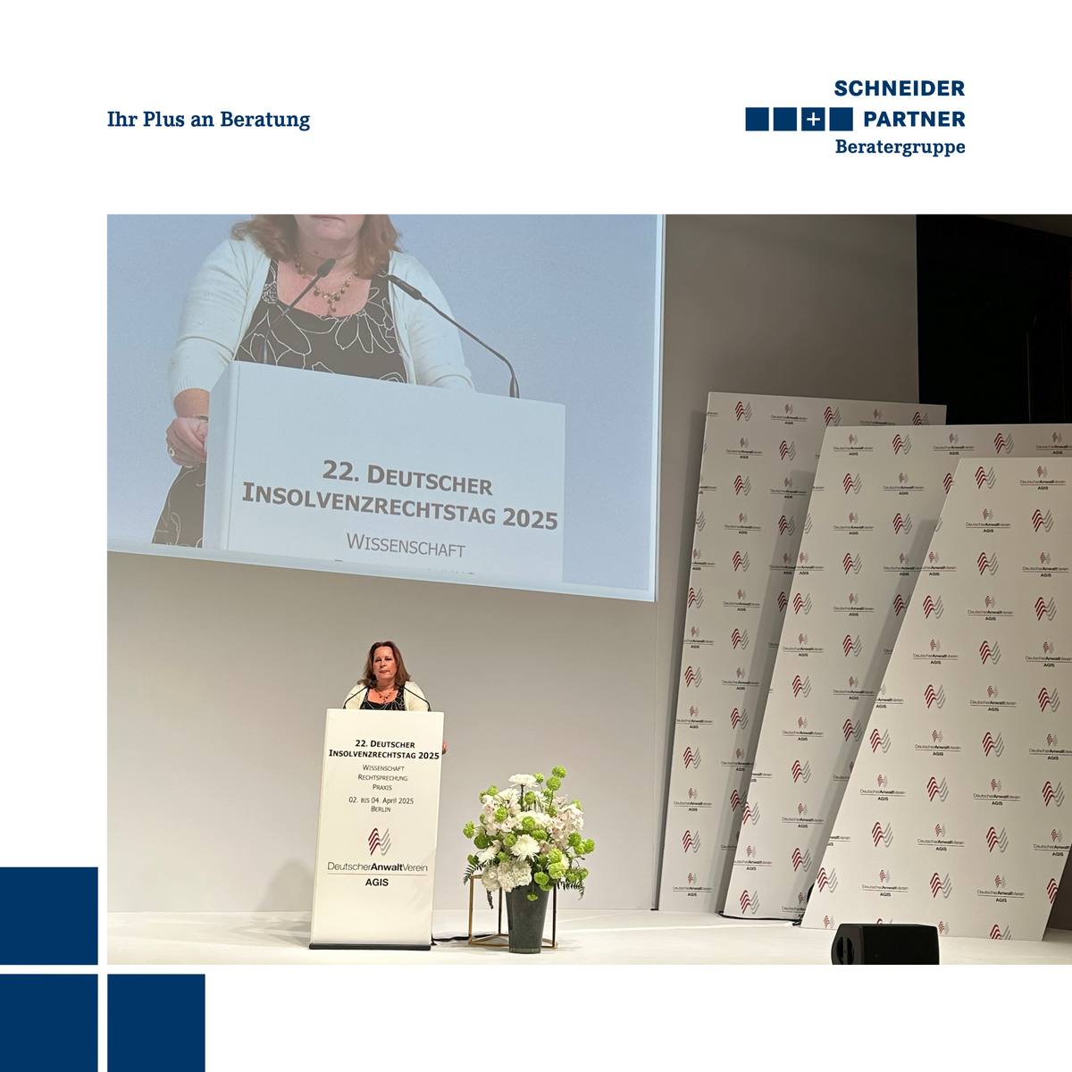 Eine Frau steht am Rednerpult und hält einen Vortrag. Hinter ihr ist eine große Leinwand zu sehen.