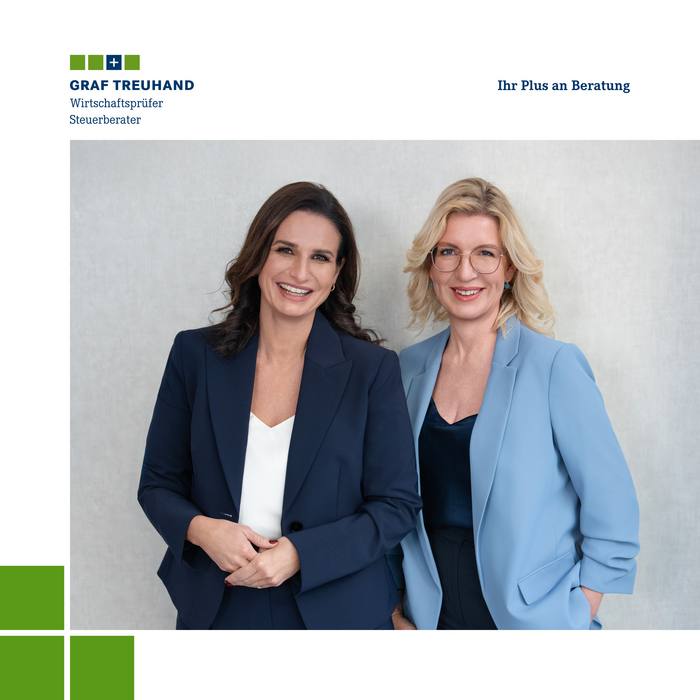 Eine brünette und eine blonde Frau im Businesslook